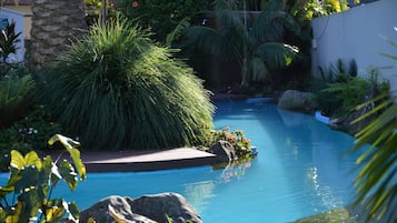 Una piscina al aire libre, sillones reclinables de piscina