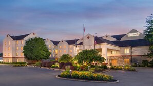 A hotel with multiple buildings, a flag, and well-maintained landscaping.