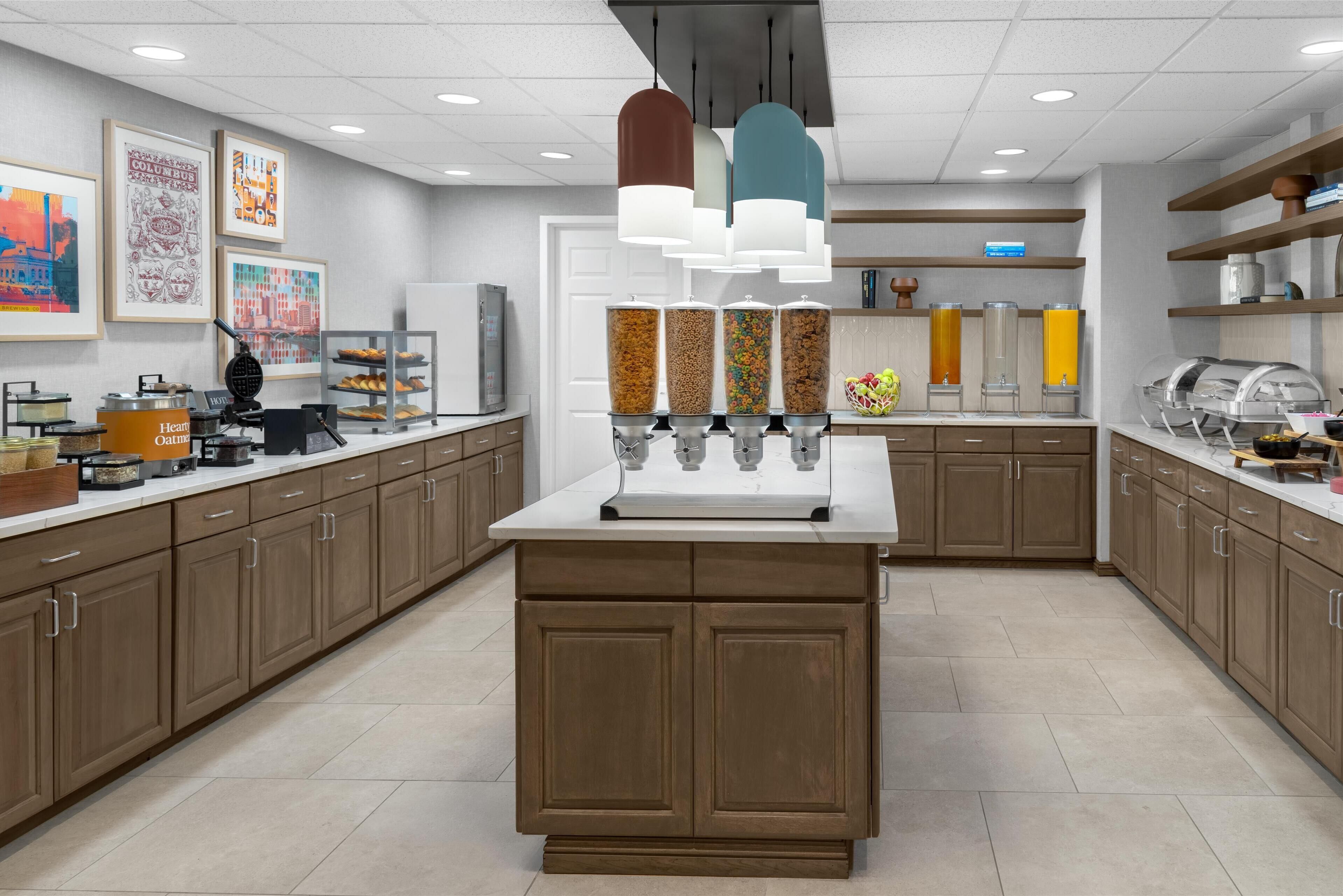 Una cocina moderna con una isla central, armarios empotrados y diferentes dispensadores de alimentos.