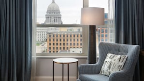 Une pièce avec vue sur un grand bâtiment en forme de dôme, un lampadaire, une chaise et une petite table.