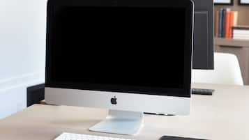 A workspace with a desktop computer, keyboard, mouse, and a monitor.