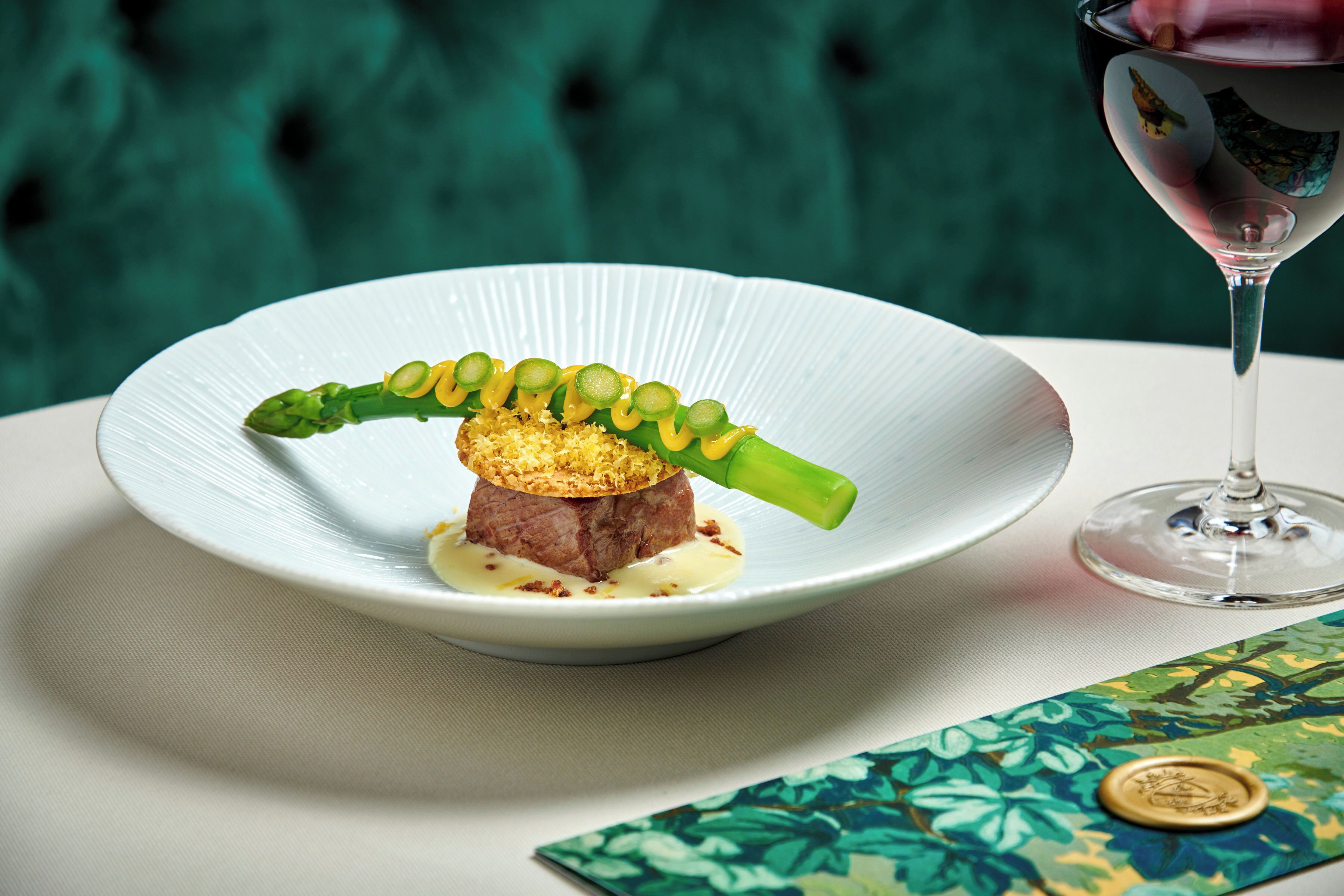 A plate of food with a glass of wine on a table.