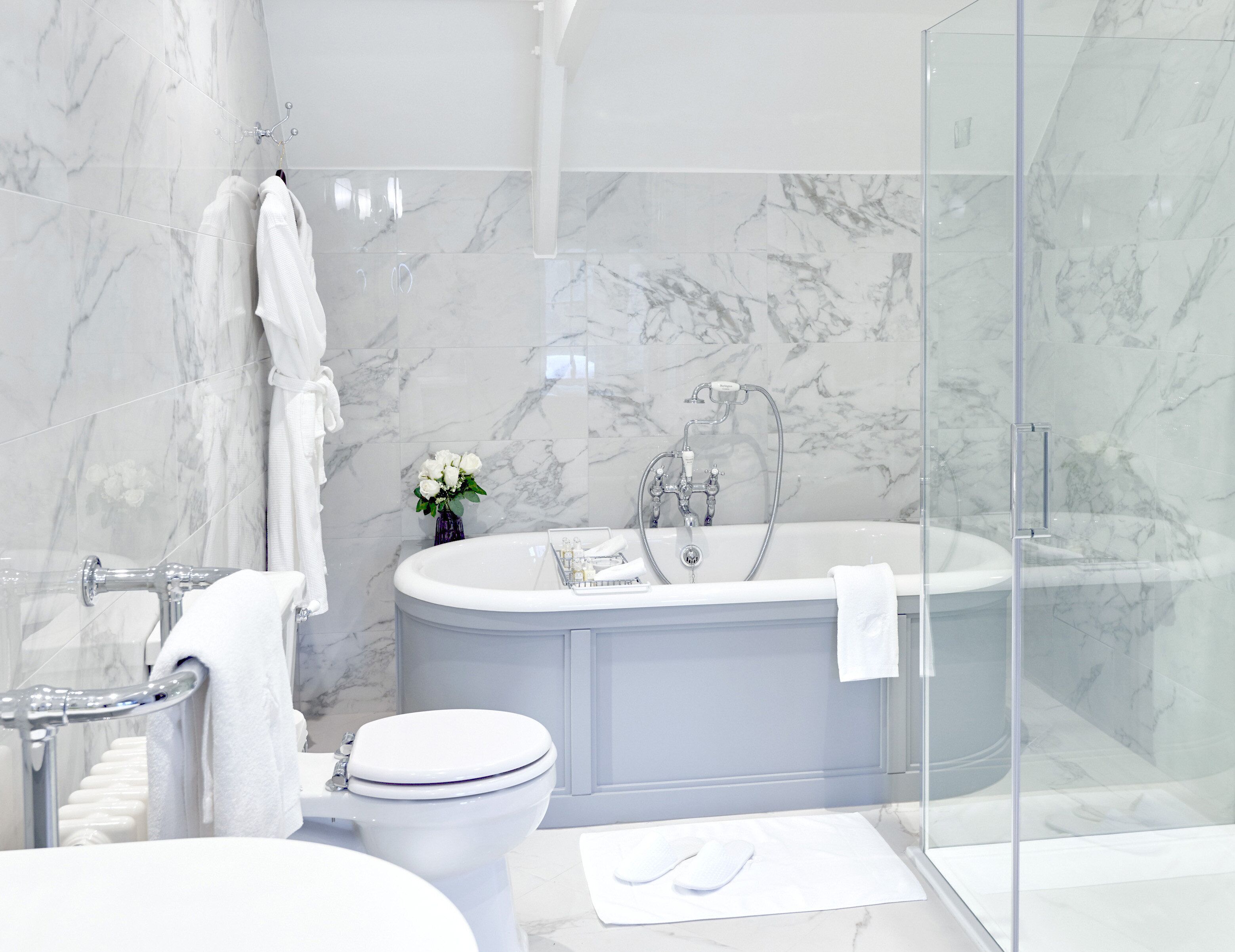 A modern bathroom with a bathtub, toilet, and shower area.