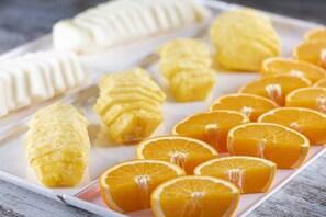 A tray with pastries and orange slices.