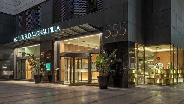 The exterior of AC Hotel Diagonal L'illa, featuring a modern facade, large glass entrance, and prominent signage. - AC Hotel Diagonal L'Illa by Marriott (Barcelona)