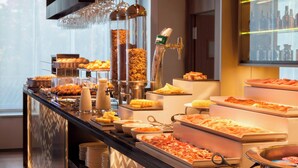 A buffet with various food items and utensils, including a coffee station and a wine cooler. - AC Hotel Diagonal L'Illa by Marriott (Barcelona)