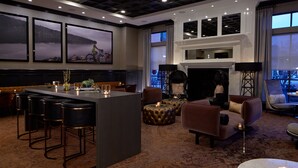 Un moderno vestíbulo de hotel con zona de bar, asientos y obras de arte en las paredes.