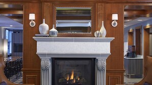 Un hall con chimenea, asientos de cuero y un candelabro.