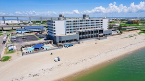 A hotel with a pool area, beach access, and a view of the ocean.