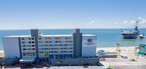 Ein DoubleTree by Hilton Hotel mit Blick auf das Meer und einem im Hintergrund liegenden Flugzeugträger.