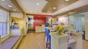 A reception area with a counter, seating, and a map on the wall. - TownePlace Suites by Marriott Raleigh Cary-Weston Parkway (Cary)