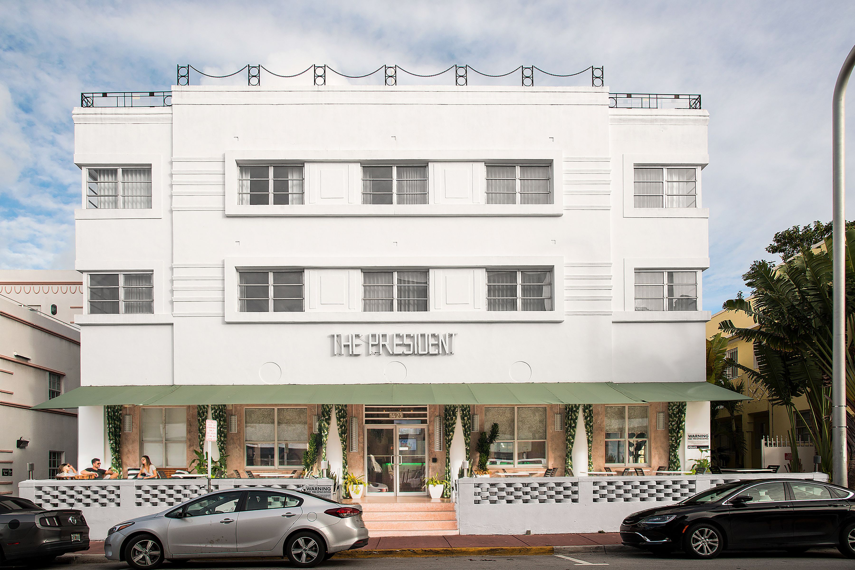 A white building with a sign reading "THE PRESIDENT" at the entrance.