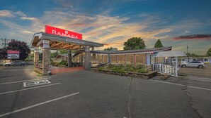 A Ramada hotel reception office with a clear sky and parking lot. - Ramada by Wyndham 1000 Islands/Gananoque (Gananoque)