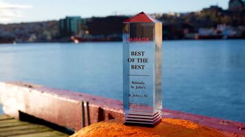 A clear award plaque on a railing with text indicating it is for 'Ramada Worldwide Best of the Best' at 'Ramada St. John's, St. John's, NL' for the years 2015-2016.