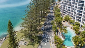 Ein Resort mit Pool, eine Straße mit Fahrzeugen und Blick auf den Ozean.