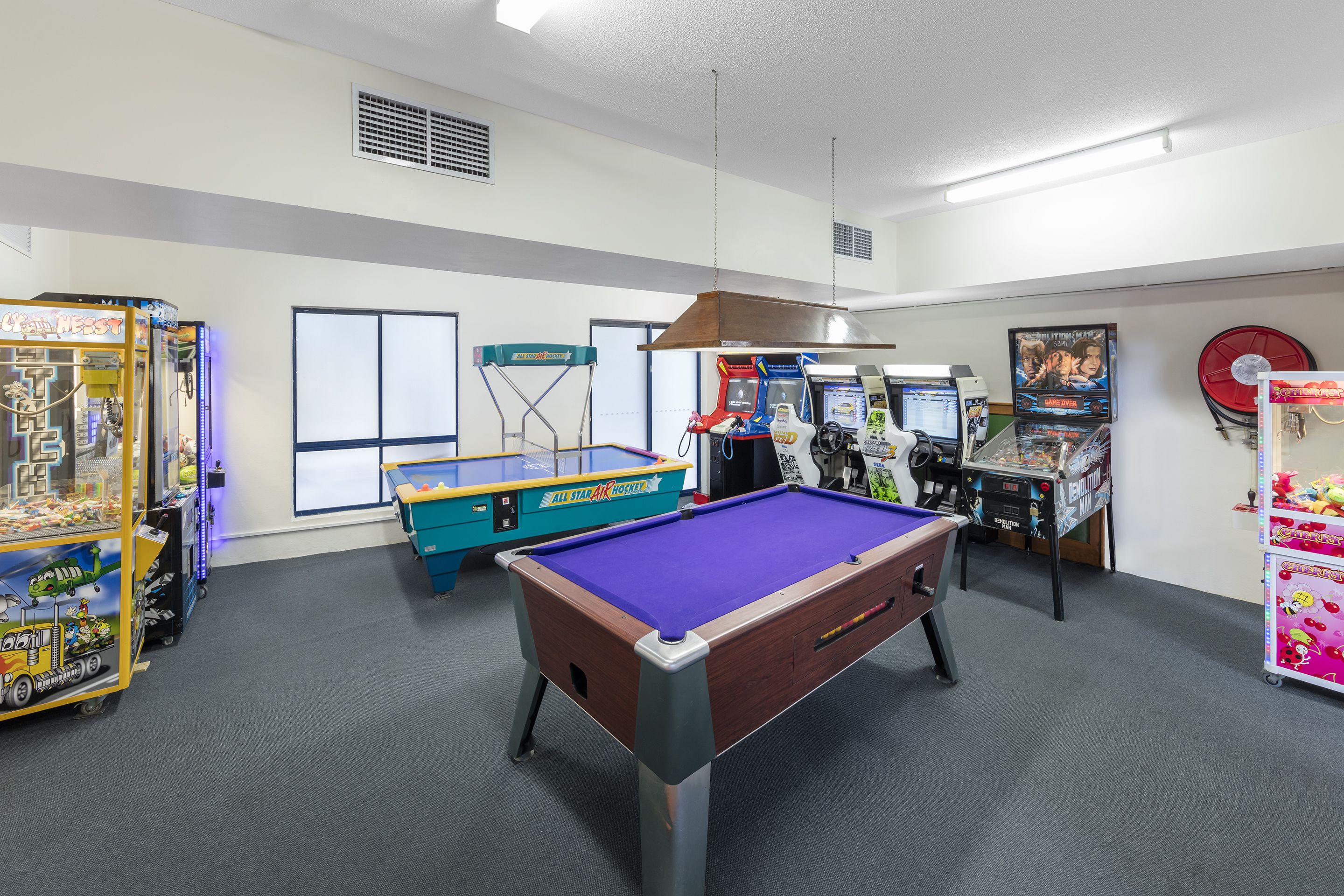 Une salle de loisirs équipée d’une table de billard, de jeux d’arcade et d’une table de baby-foot.