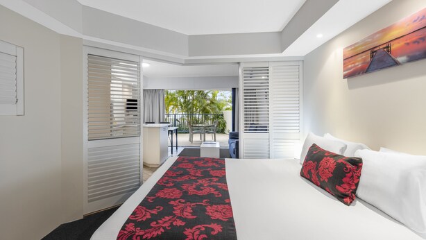 Une chambre d’hôtel avec un lit, une vue sur le balcon et un tableau au mur.