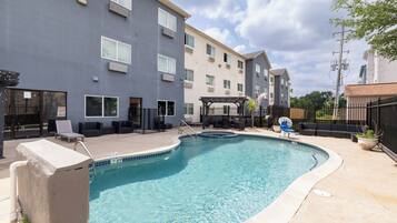 Alberca al aire libre y camastros