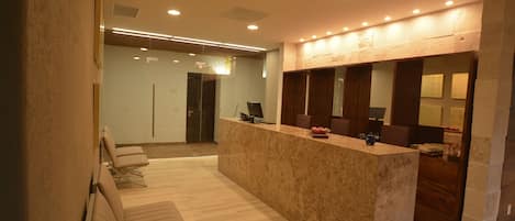 A reception area with a marble counter, seating, and a modern interior design.
