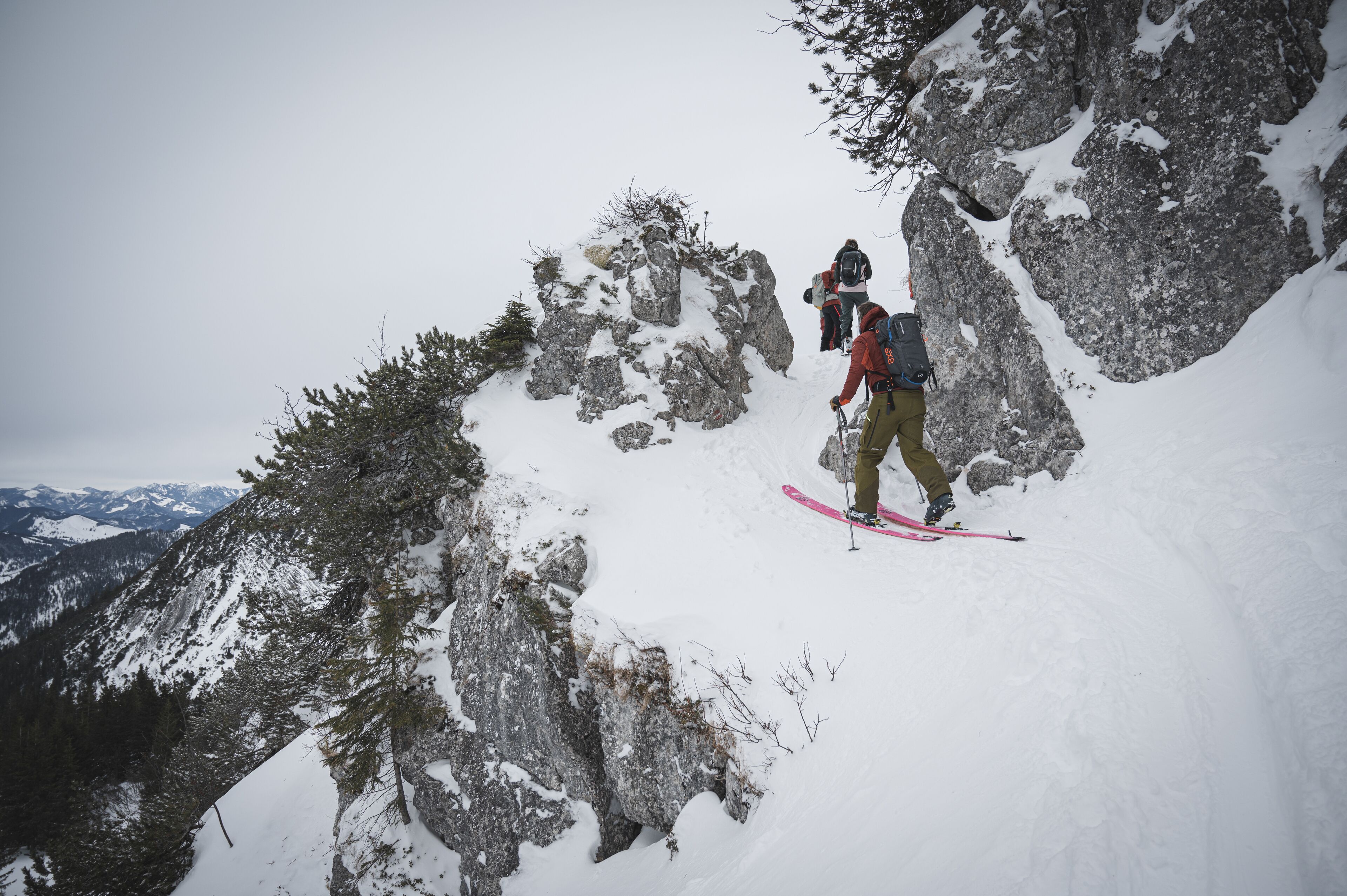 En person står på ski i et sneklædt bjerglandskab.