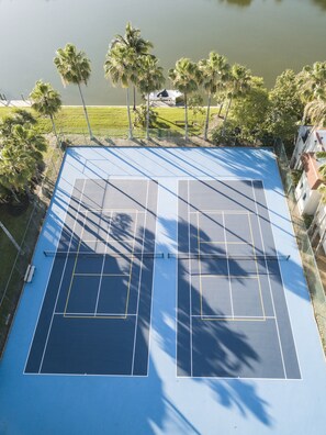 Enjoy tennis amidst lush greenery and serene lake views.