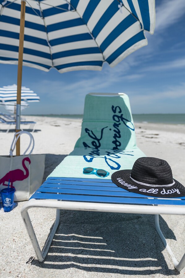 Relax in a beachside lounge chair with a personalized message and umbrella overhead.