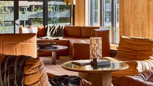 A modern interior with wooden beams, a large window, and a cozy seating area. - Bluebird Cady Hill Lodge (Stowe)