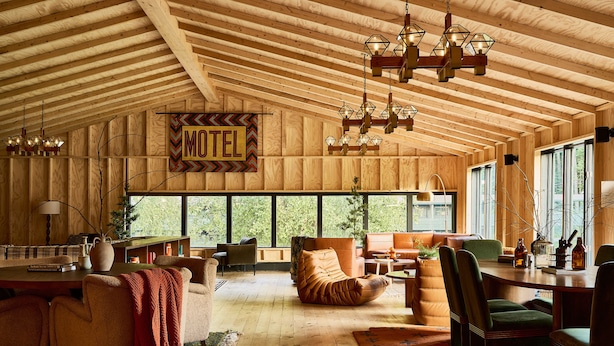 A spacious room with a wooden ceiling, a 'Motel' sign, a large window, and a cozy seating area. - Bluebird Cady Hill Lodge (Stowe)