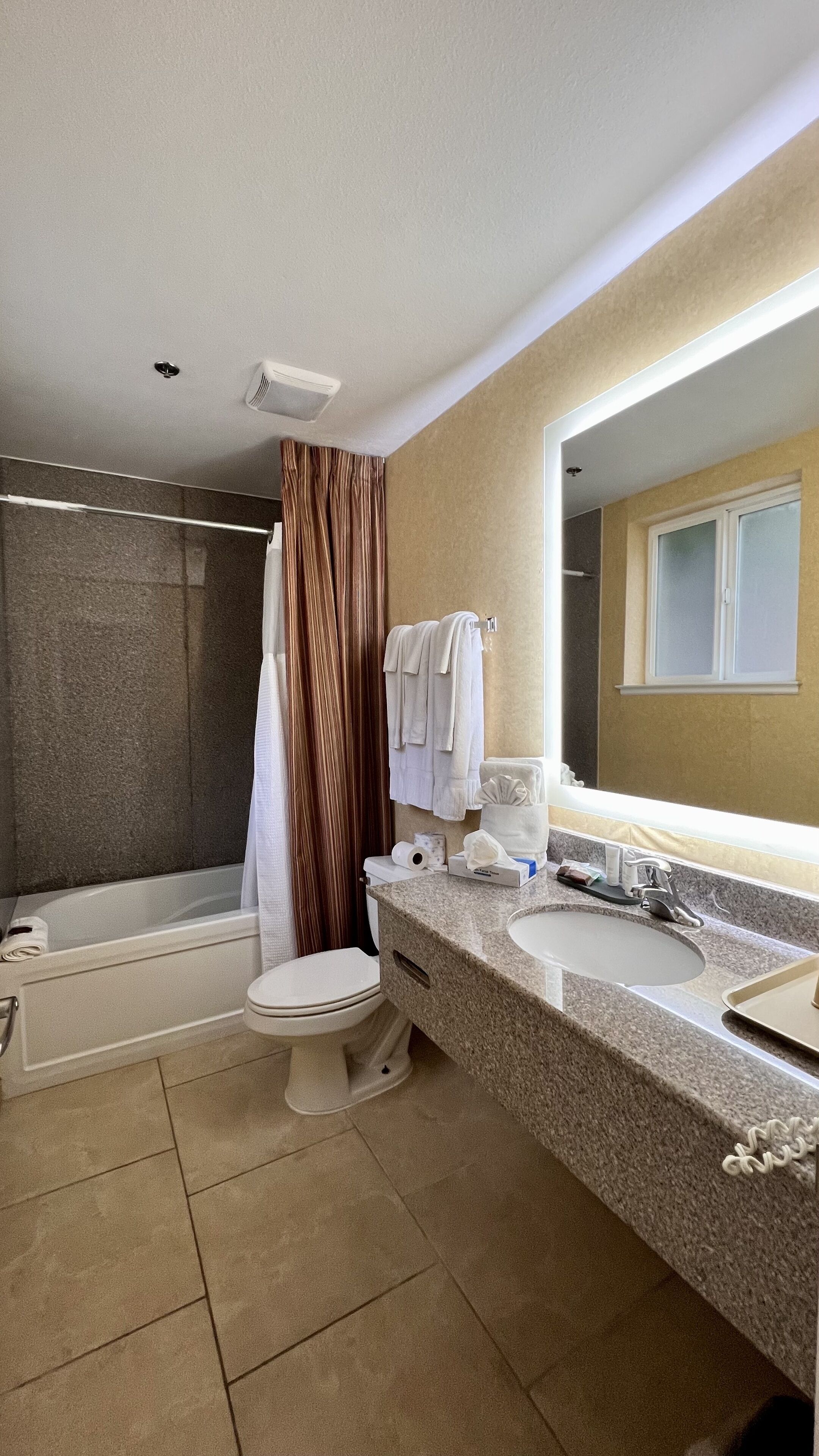 Ein modernes Badezimmer mit Badewanne, Toilette und Waschbecken.