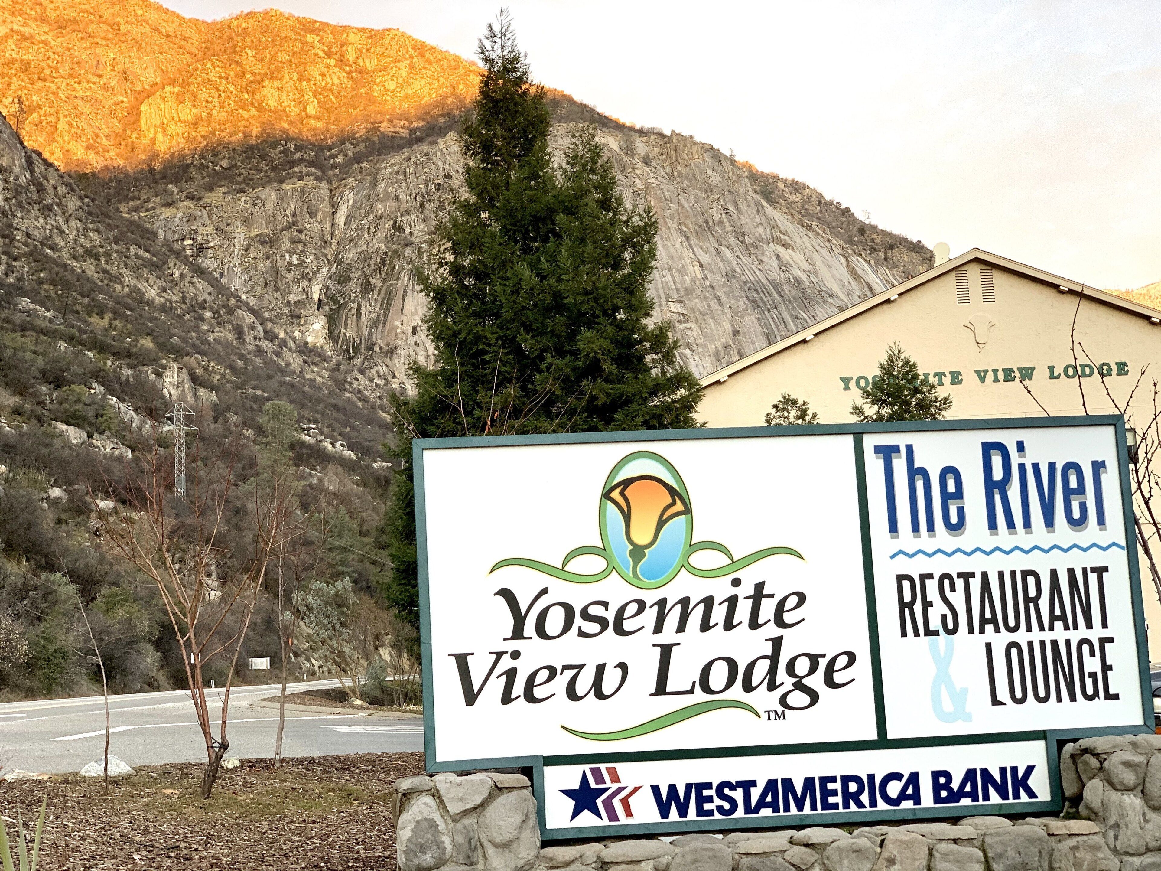Skilt for Yosemite View Lodge med bjergudsigt.
