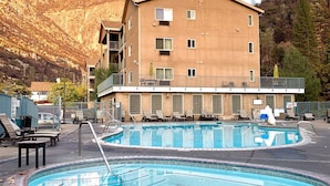 A hotel with a pool area, including two pools and lounge chairs. - Yosemite View Lodge (El Portal)