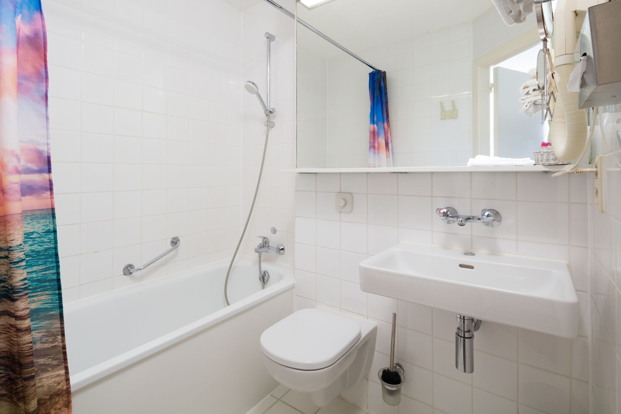 Un baño con bañera, inodoro y lavamanos.