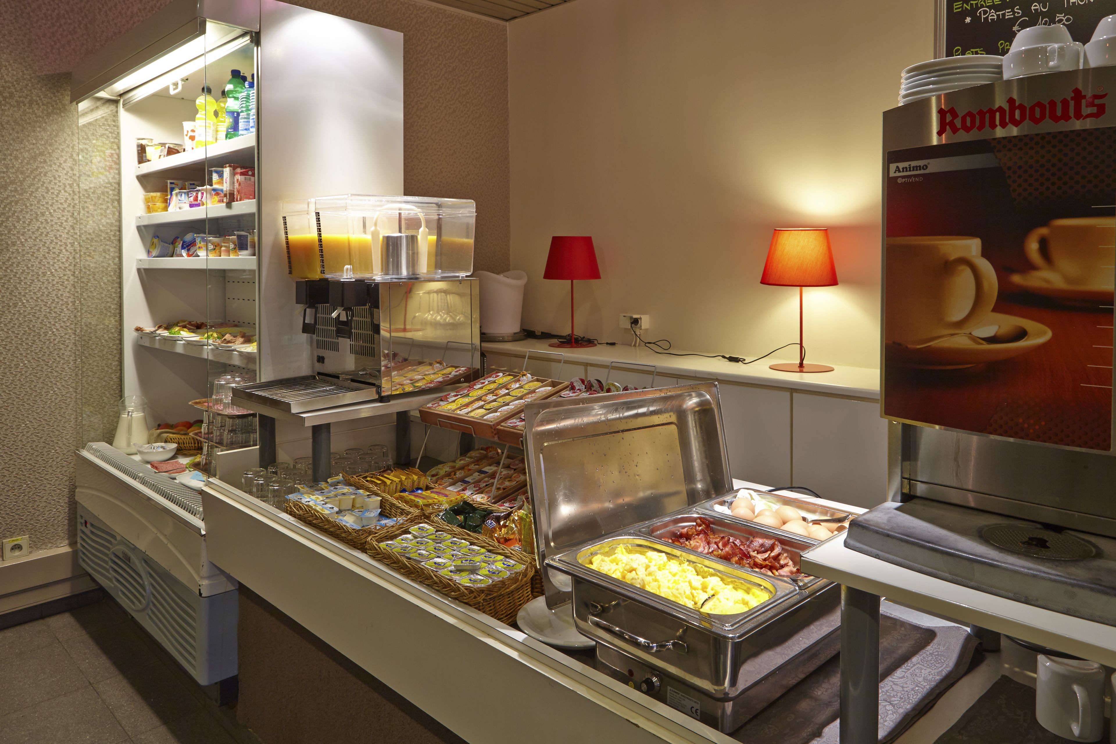 A buffet area with various food options, including a coffee station and a beverage dispenser.