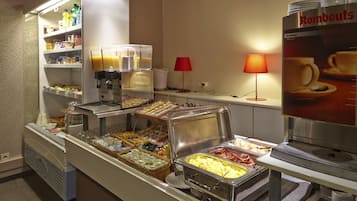 A buffet area with various food options, including a coffee station and a beverage dispenser.