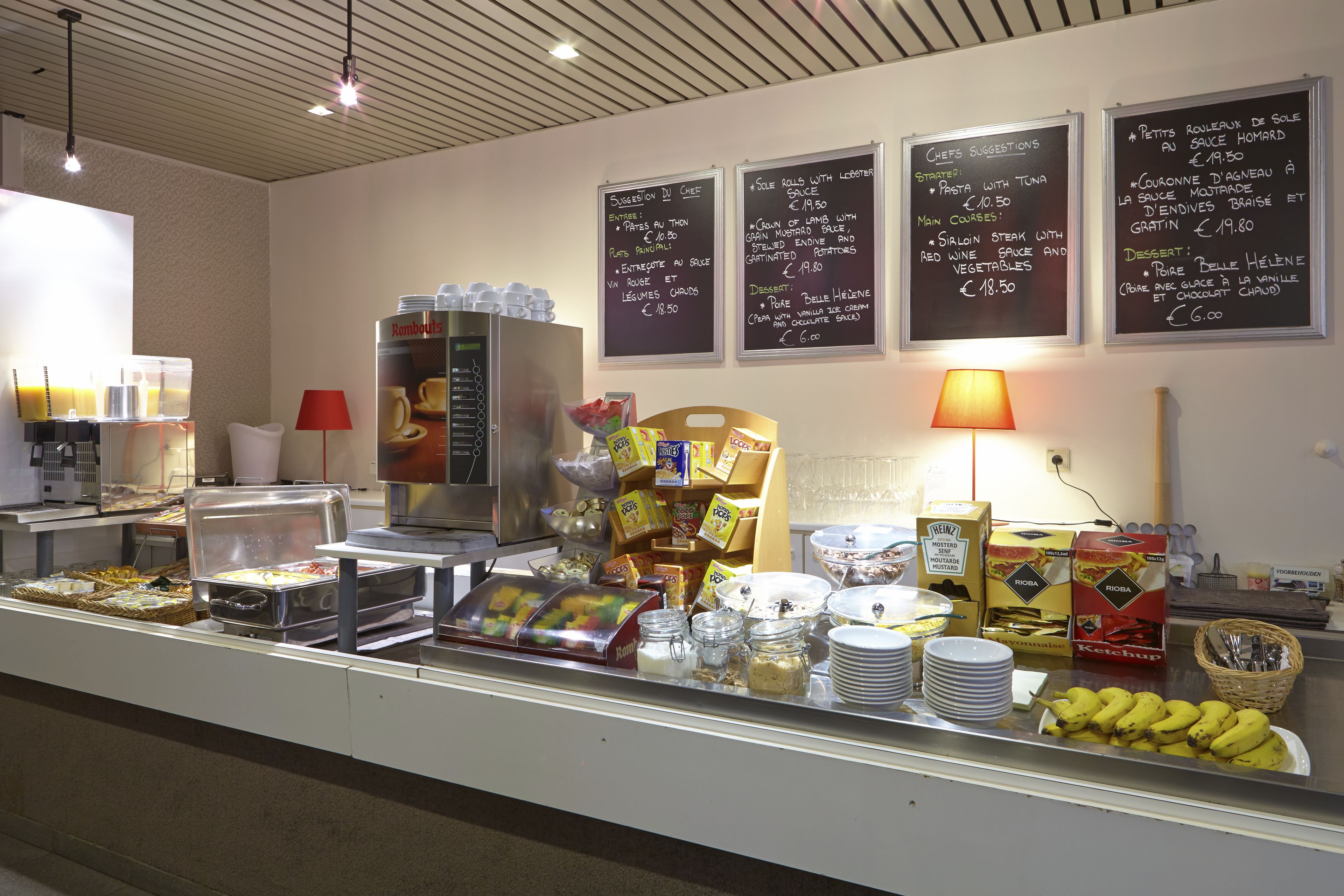 Een buffetgedeelte met diverse gerechten en een menubord waarop de opties staan.