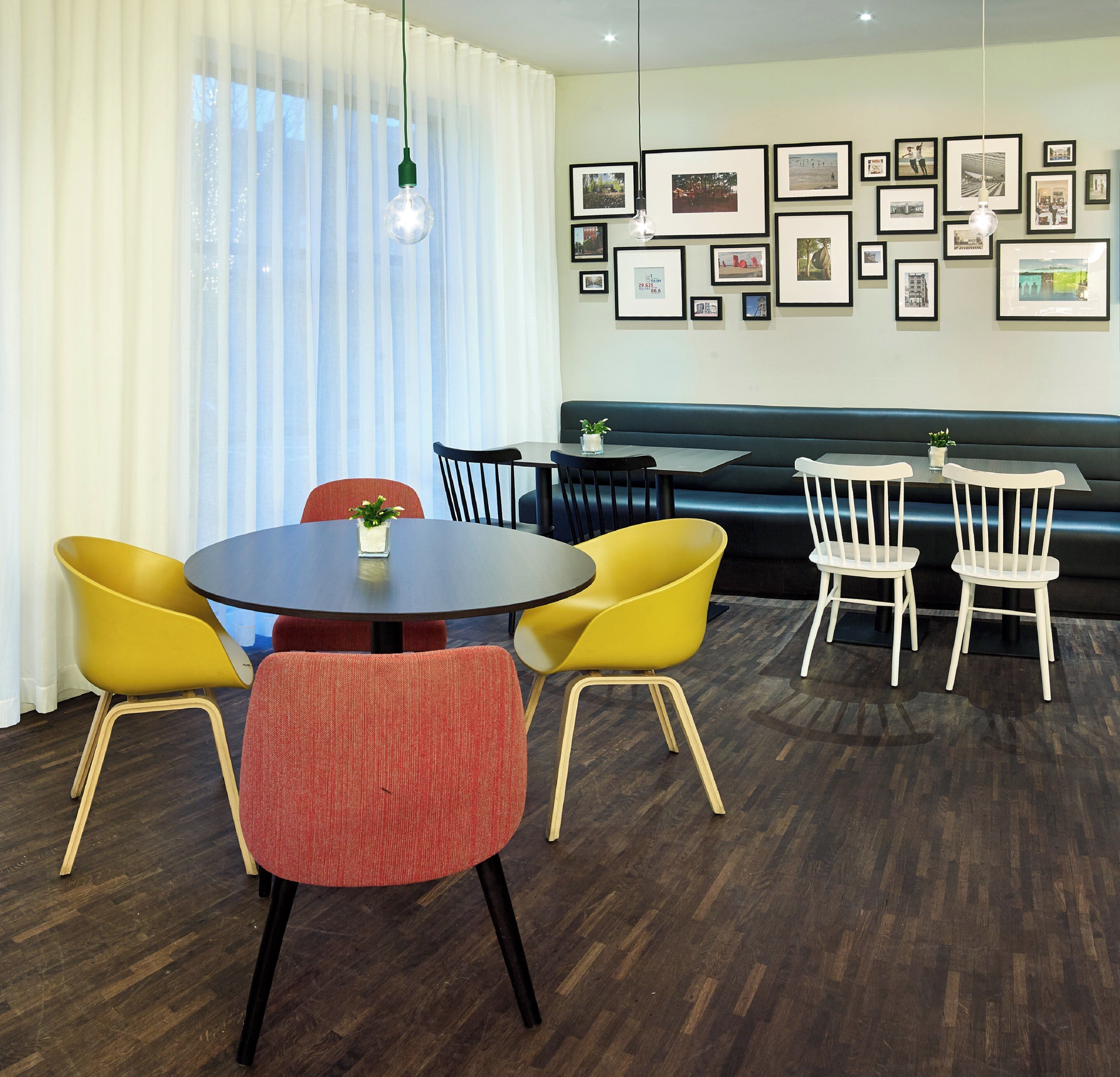 A dining area with a round table, chairs, and a sofa.