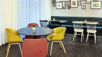 A dining area with a round table, chairs, and a sofa.
