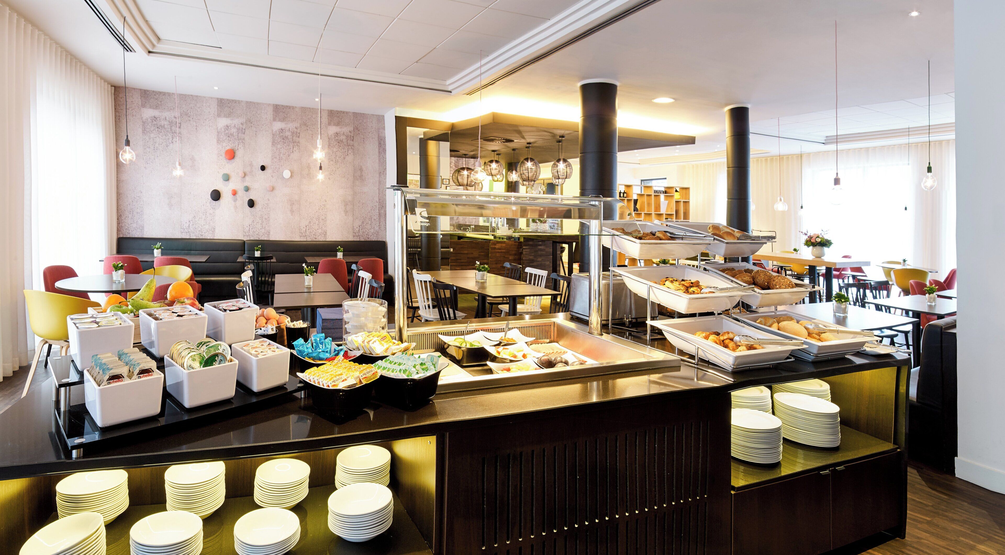 A buffet area with various food options, seating arrangements, and a modern interior design.