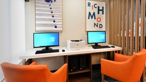 A workspace with two monitors, a printer, and two orange chairs. - Holiday Inn Express Richmond I-64 Short Pump Area by IHG (Richmond)