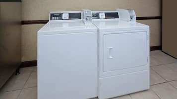 A front-loading white washer and dryer unit with control panels and a digital display.
