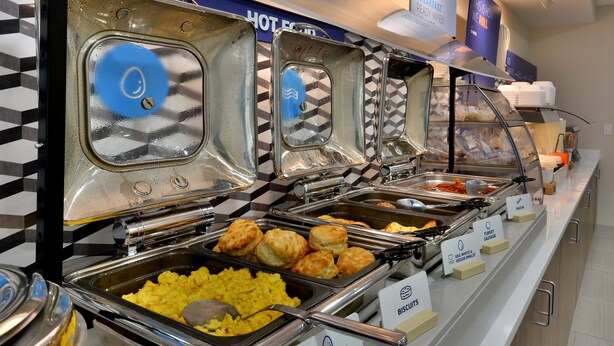 A buffet with labeled sections for scrambled eggs, biscuits, turkey sausage, and other items. - Holiday Inn Express Richmond I-64 Short Pump Area by IHG (Richmond)
