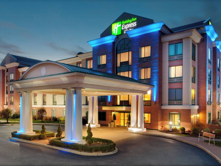 A Holiday Inn Express hotel with a modern design, featuring a covered entrance and a well-lit facade.