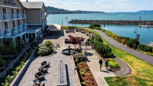 A hotel with a waterfront patio, outdoor seating, and a view of the lake.