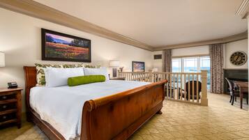 Un dormitorio espacioso con una cama grande, un balcón con barandilla y vistas al mar.