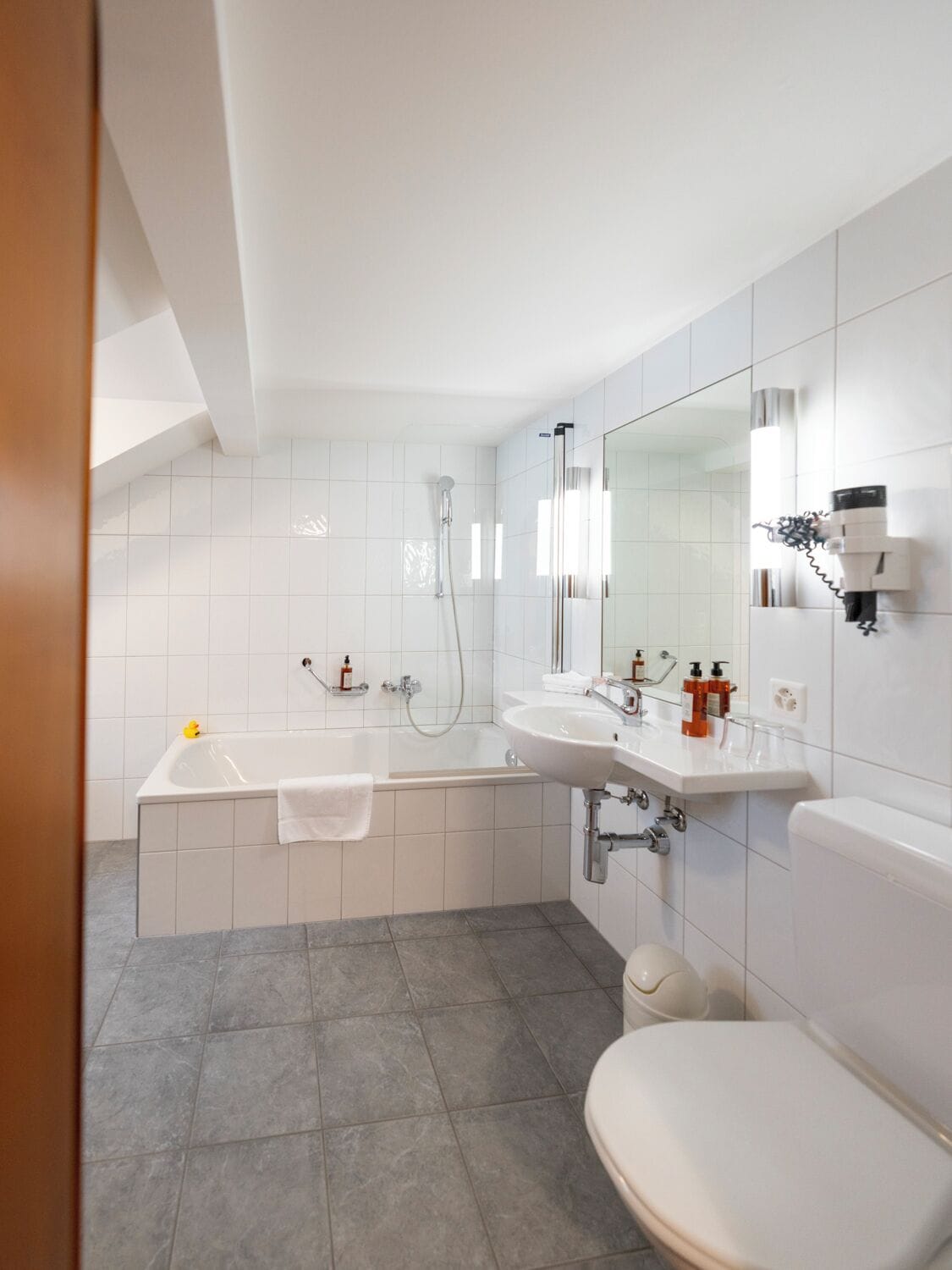 A modern bathroom with a bathtub, a sink, and a toilet.