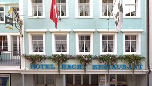 A hotel with a sign reading "HOTEL HECHT RESTAURANT" and a red flag.