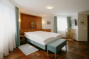 Relax in comfort with a large bed, wooden floor, and a cozy seating area.
