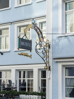 Une enseigne d’hôtel avec un cadre en métal décoratif et un ornement suspendu.