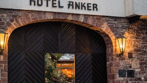 The entrance of Hotel Anker with a large arched doorway, a statue above the entrance, and the hotel's name displayed above. - Hotel Anker (Marktheidenfeld)