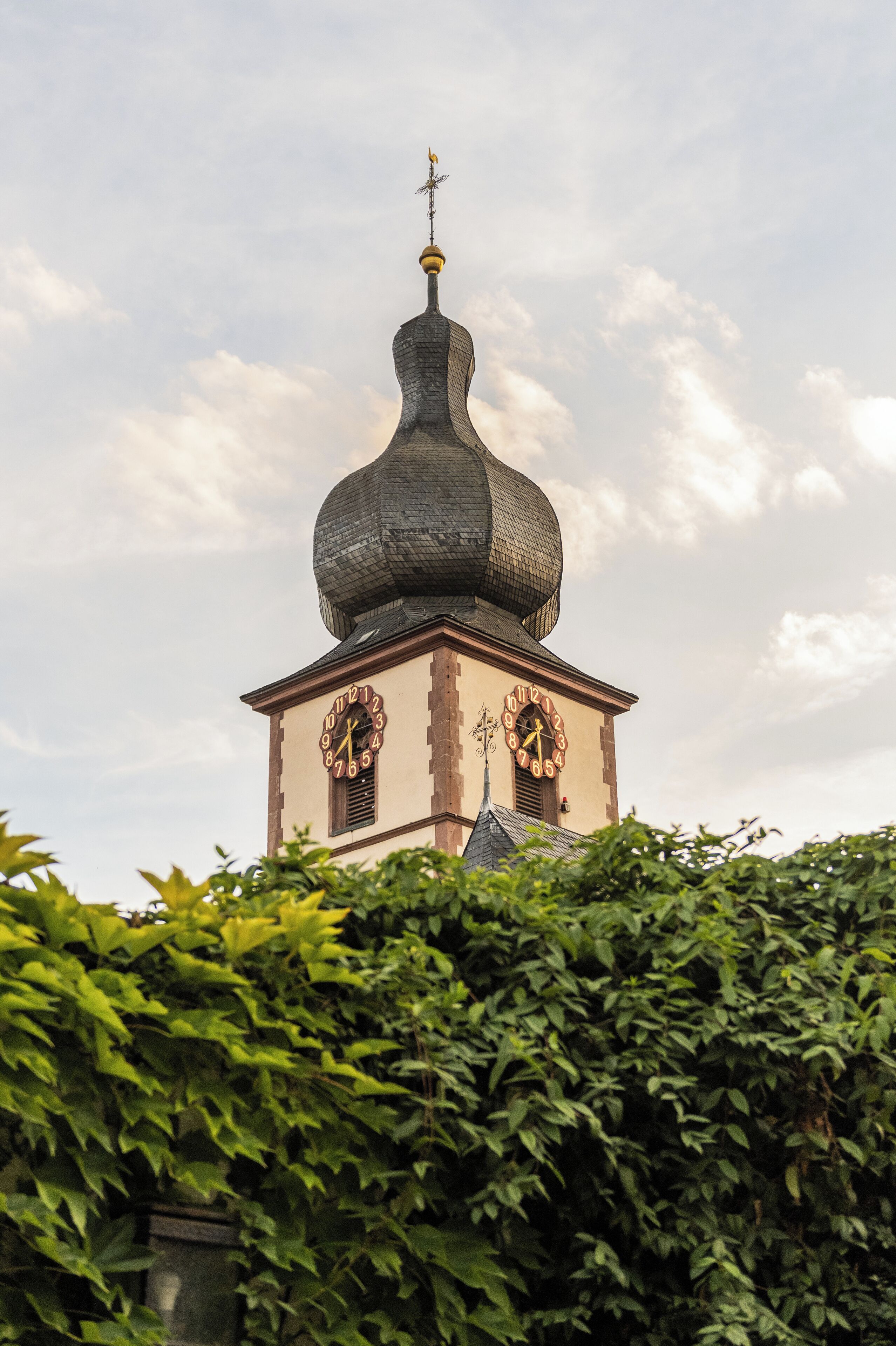 A church with a distinctive onion-shaped dome and two visible clocks on its facade.